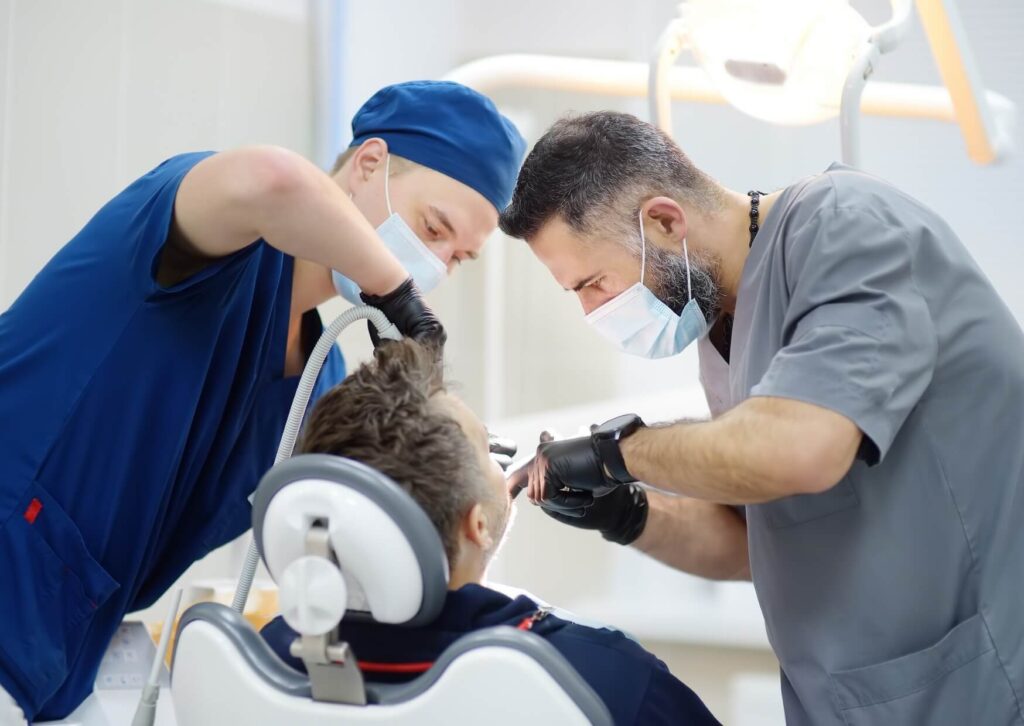 Dental professionals evaluating a patient for implant treatment, assessing oral health and bone support before determining eligibility for dental implants.