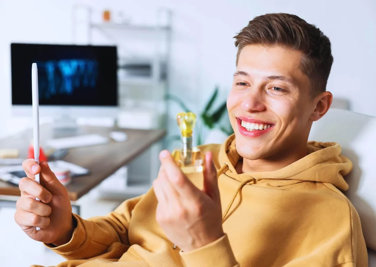 Patient viewing a dental implant model while learning about dental implant lifespan and long-term care.