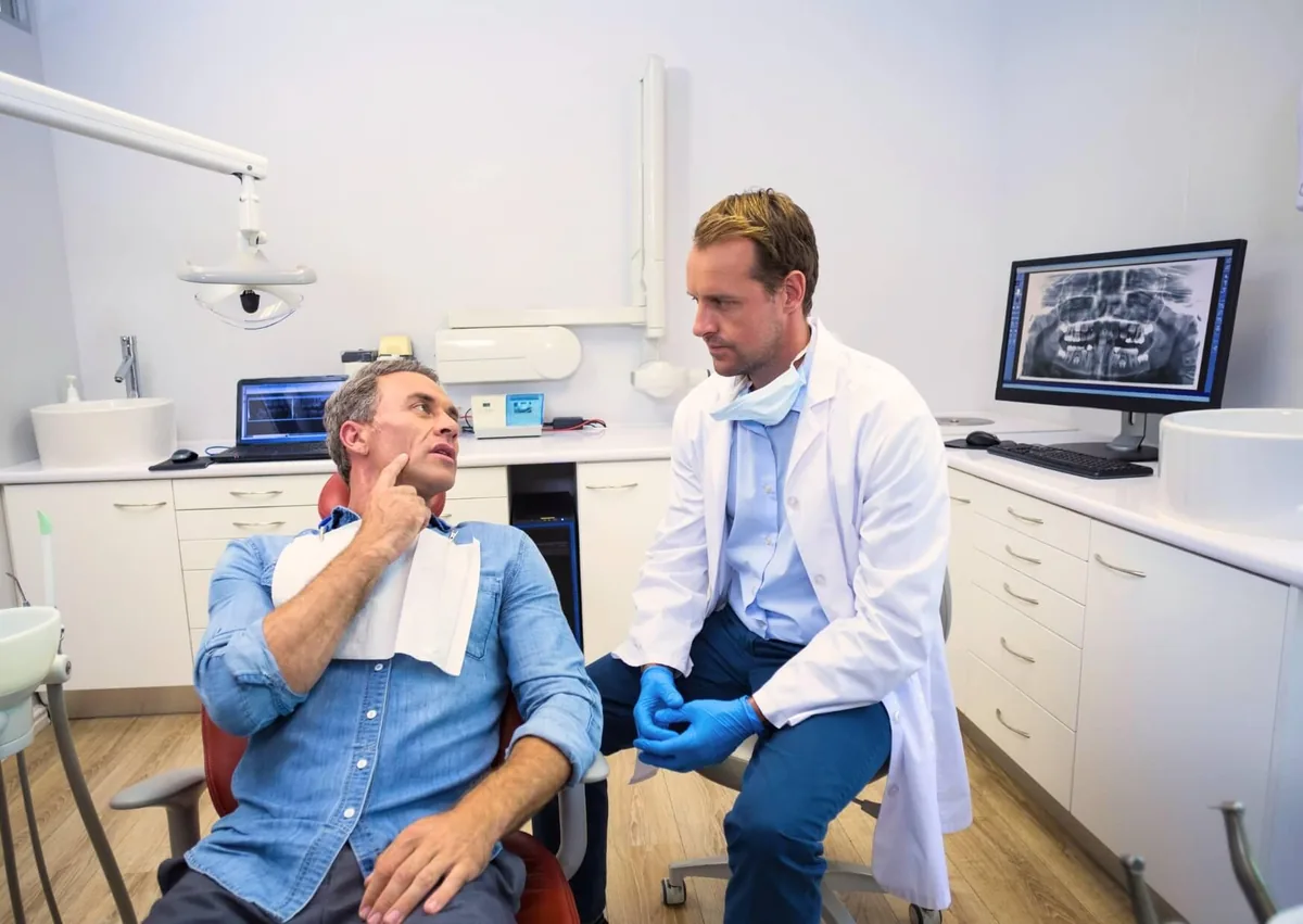 Dentist discussing dental implant lifespan and long-term treatment outcomes with a patient.